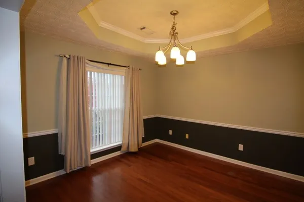 an empty room with wooden floor and large window