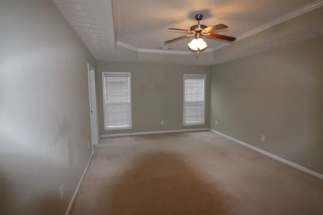 a view of an empty room with a ceiling fan and window