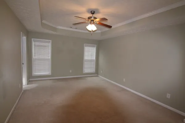 a view of an empty room with a chandelier fan