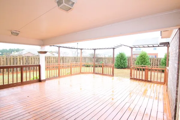 a view of hallway with wooden floor and fence