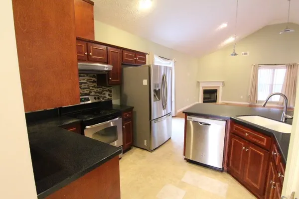 a kitchen with stainless steel appliances granite countertop a refrigerator and a sink