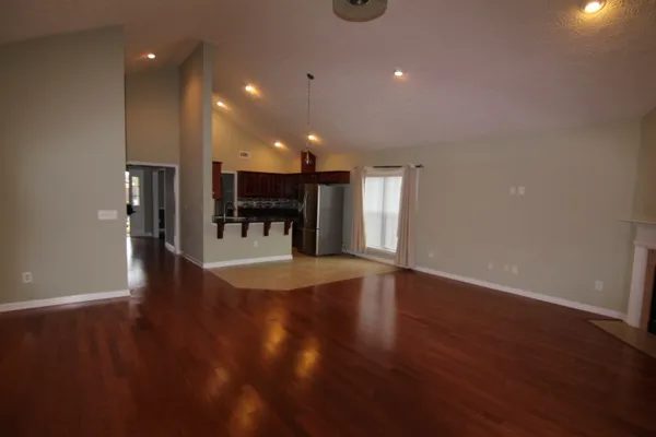 a view of a big room with wooden floor and a window