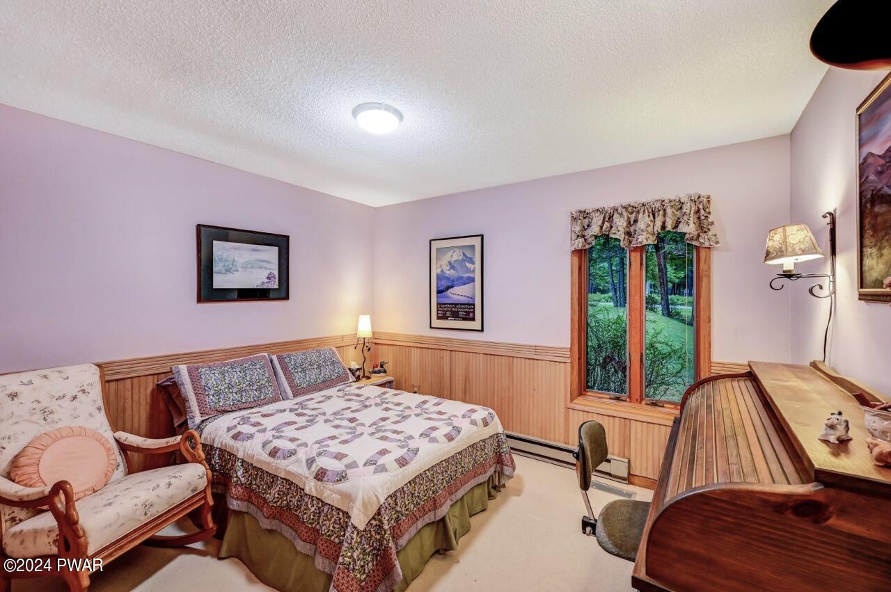 141 Maple Ridge Drive Hawley, PA 18428 - Photo 60 of 84 a bedroom with a bed and a table in it