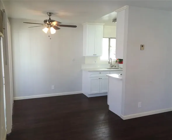 a view of a room with wooden floor and fan