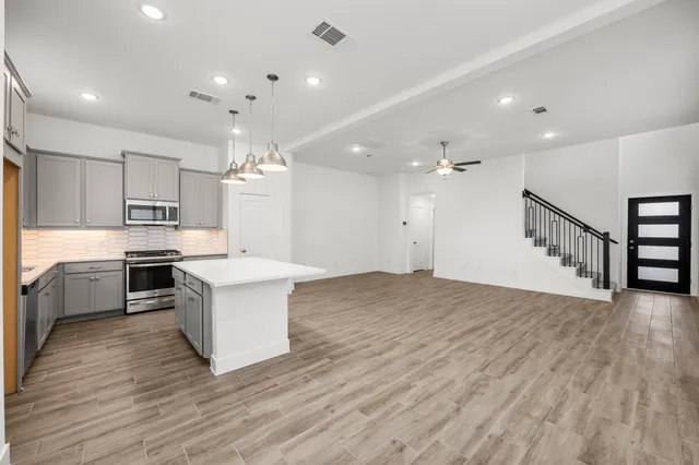 a kitchen with a sink cabinets and wooden floor