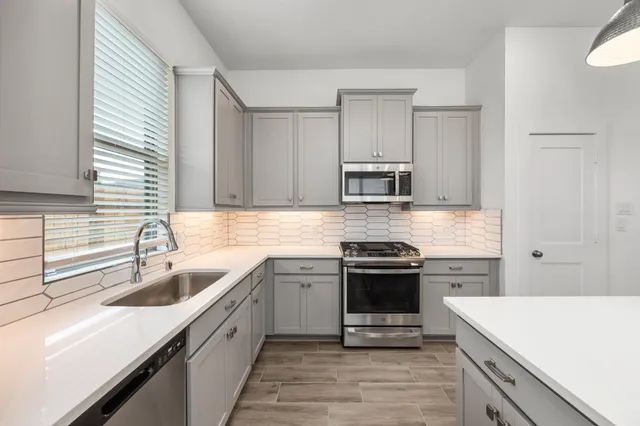a kitchen with stainless steel appliances granite countertop a sink stove and refrigerator