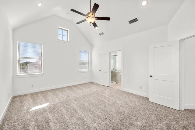 an empty room with ceiling fan and window