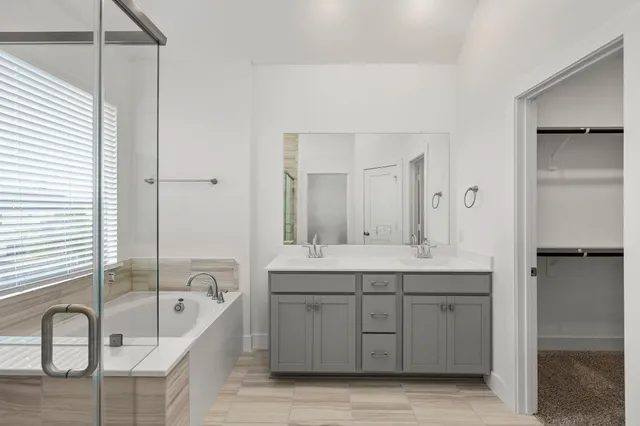 a bathroom with a tub sink and mirror