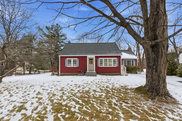a front view of a house with a yard covered with snow