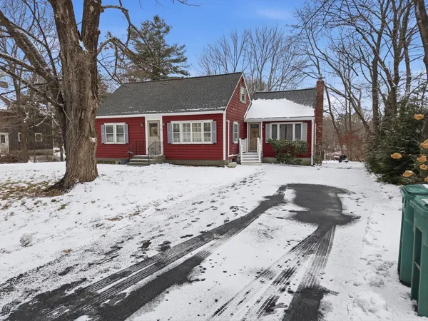 a front view of a house with a yard covered with snow