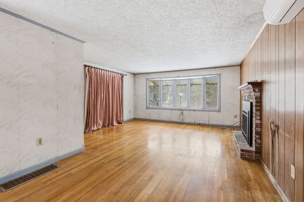 an empty room with wooden floor and a window