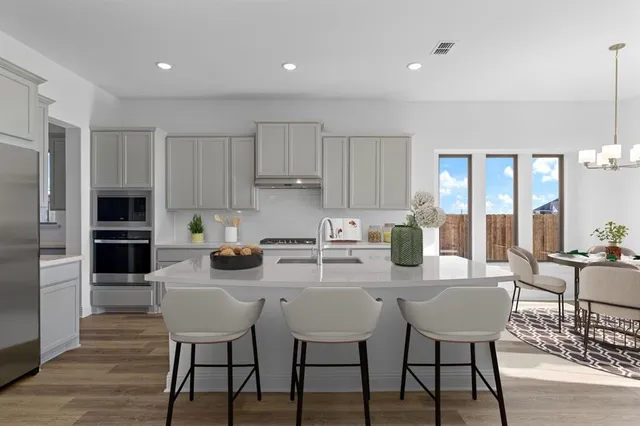 a kitchen with a dining table chairs and refrigerator