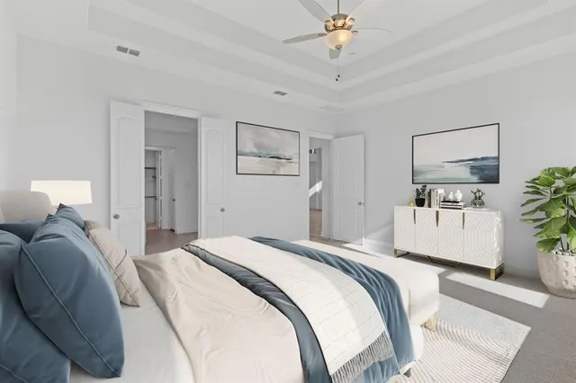 a spacious bedroom with a bed and a chandelier