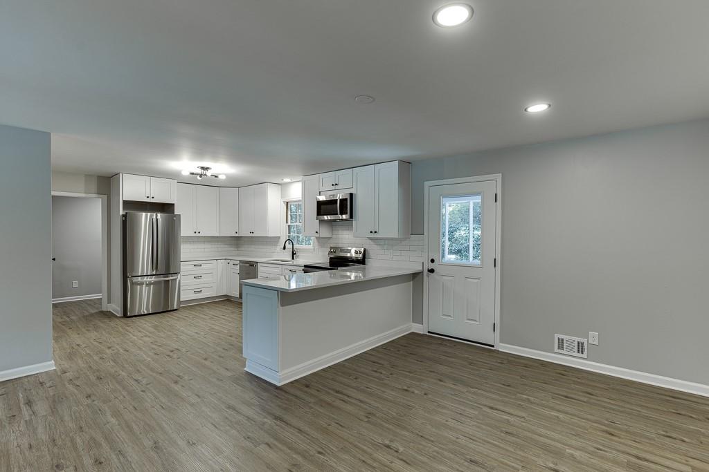5837 Meadow View Lane Flowery Branch, GA 30542 - Photo 12 of 47 a kitchen with stainless steel appliances a refrigerator and a stove top oven