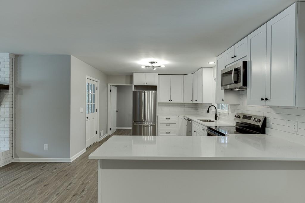 5837 Meadow View Lane Flowery Branch, GA 30542 - Photo 15 of 47 a kitchen with stainless steel appliances granite countertop a sink a stove and a refrigerator