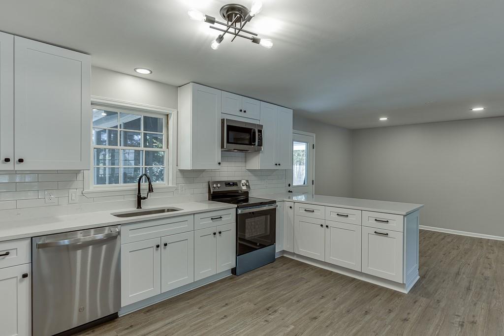 5837 Meadow View Lane Flowery Branch, GA 30542 - Photo 16 of 47 a kitchen with a sink cabinets and wooden floor