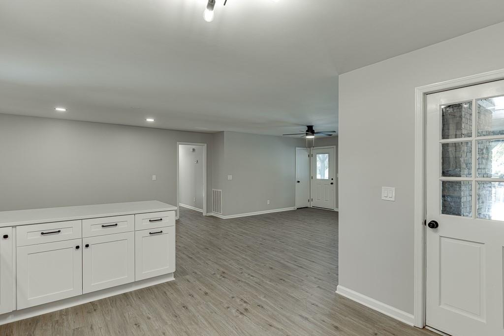 5837 Meadow View Lane Flowery Branch, GA 30542 - Photo 17 of 47 an empty room with wooden floor and cabinet