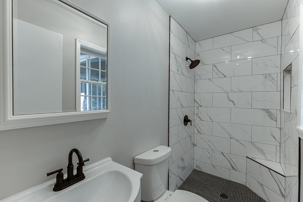 5837 Meadow View Lane Flowery Branch, GA 30542 - Photo 24 of 47 a bathroom with a toilet sink and shower