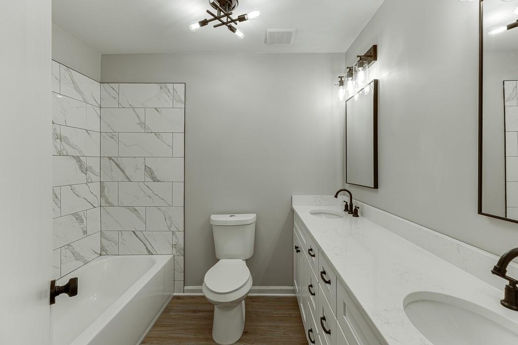 5837 Meadow View Lane Flowery Branch, GA 30542 - Photo 31 of 47 a bathroom with a sink a toilet and bathtub