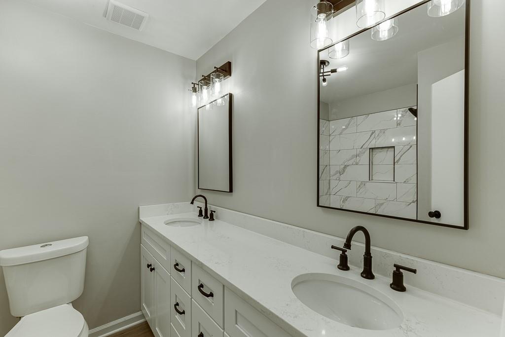 5837 Meadow View Lane Flowery Branch, GA 30542 - Photo 32 of 47 a bathroom with a toilet sink and mirror