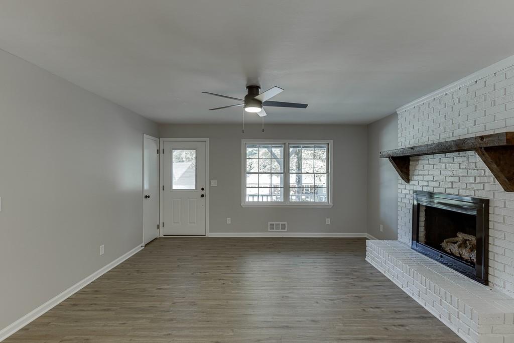 5837 Meadow View Lane Flowery Branch, GA 30542 - Photo 6 of 47 an empty room with windows and fireplace