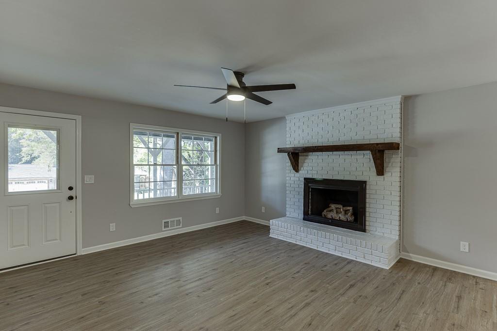 5837 Meadow View Lane Flowery Branch, GA 30542 - Photo 8 of 47 wooden floor fireplace and windows in an empty room