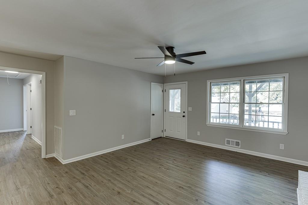 5837 Meadow View Lane Flowery Branch, GA 30542 - Photo 10 of 47 an empty room with wooden floor and windows