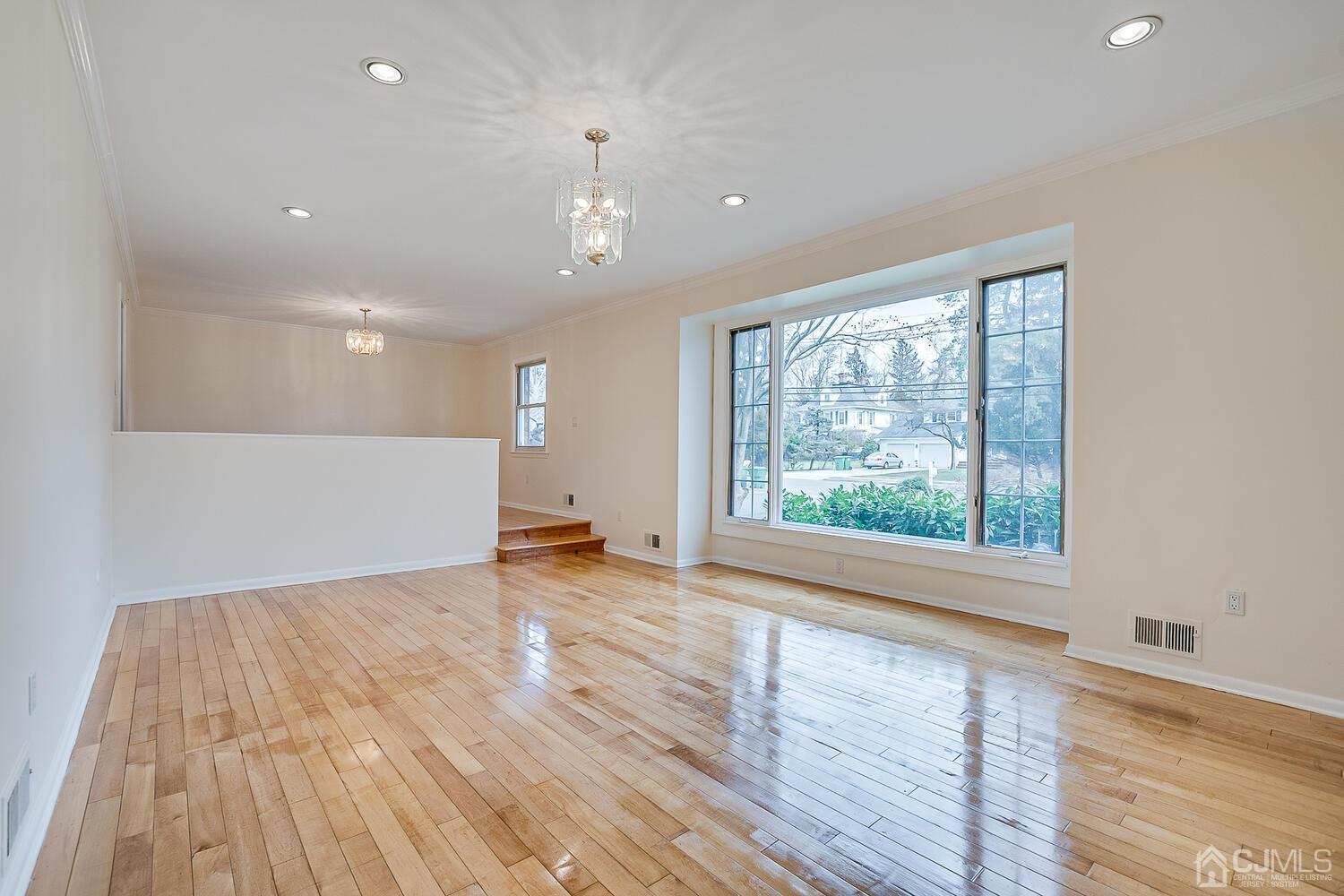 5 Robin Road Edison, NJ 08820 - Photo 5 of 43 a view of an empty room with wooden floor and a window