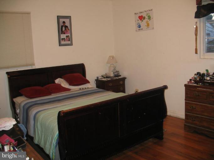 12409 Denley Road Silver Spring, MD 20906 - Photo 6 of 15 a bedroom with a bed and wooden floor
