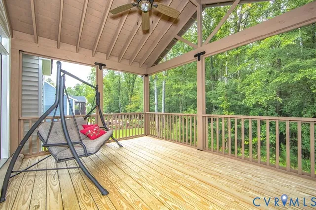 a view of balcony with wooden floor and fence next to a yard