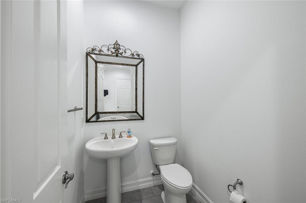 1488 Mockingbird Drive Naples, FL 34120 - Photo 12 of 38 a bathroom with a sink a mirror and a toilet