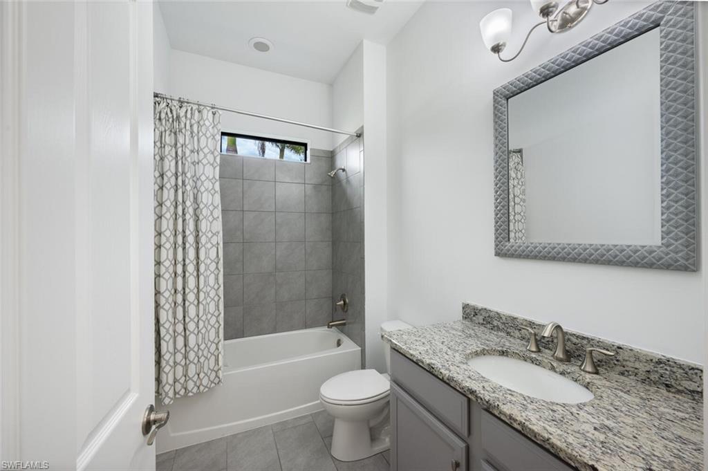 1488 Mockingbird Drive Naples, FL 34120 - Photo 19 of 38 a bathroom with a granite countertop sink toilet mirror and shower