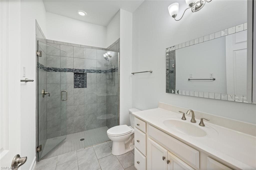 1488 Mockingbird Drive Naples, FL 34120 - Photo 22 of 38 a bathroom with a granite countertop sink a toilet and shower