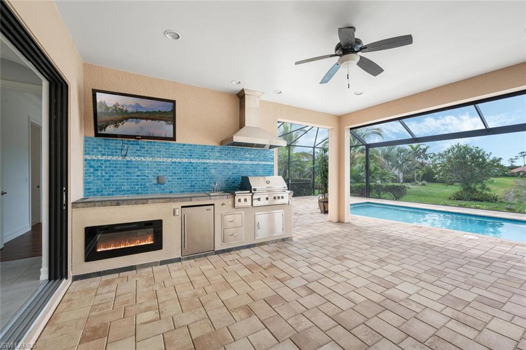 1488 Mockingbird Drive Naples, FL 34120 - Photo 26 of 38 a kitchen with stainless steel appliances granite countertop a stove a sink and a microwave oven