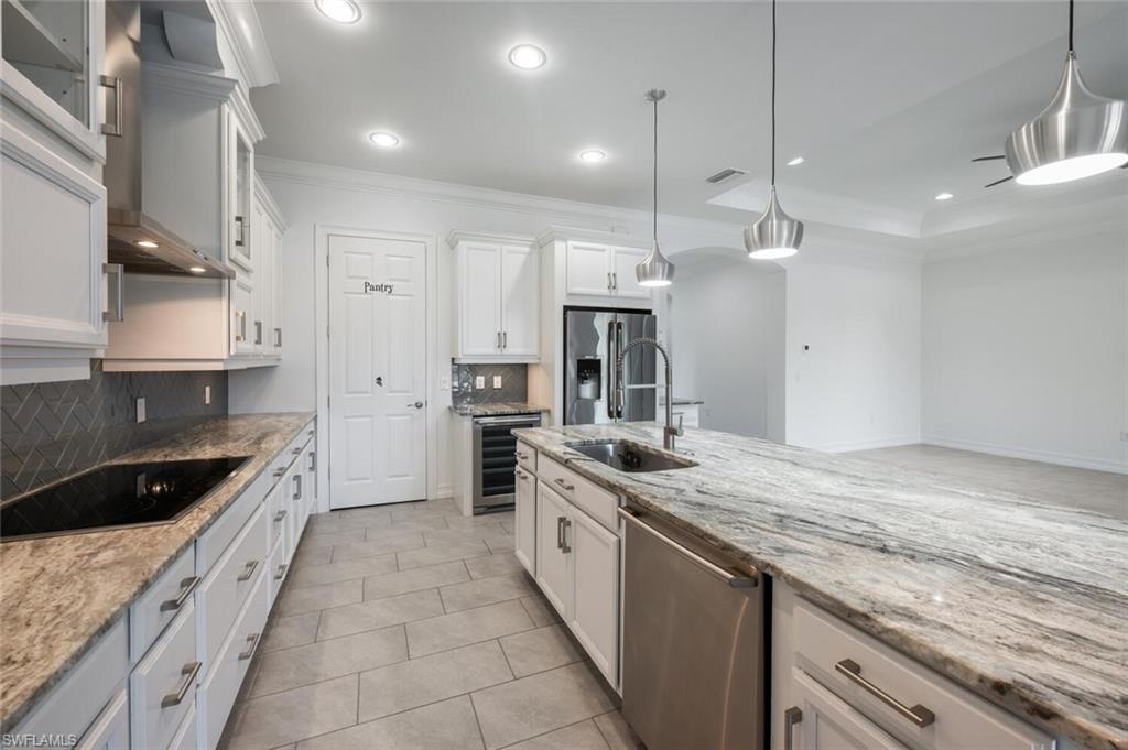 1488 Mockingbird Drive Naples, FL 34120 - Photo 6 of 38 a large kitchen with stainless steel appliances granite countertop a sink a stove and a refrigerator