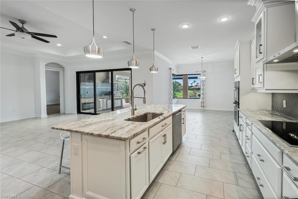 1488 Mockingbird Drive Naples, FL 34120 - Photo 7 of 38 a large kitchen with stainless steel appliances granite countertop a stove a sink and a refrigerator