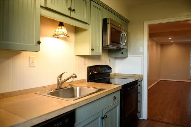a kitchen with stainless steel appliances granite countertop a sink a stove and microwave