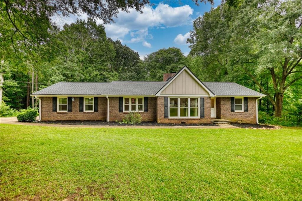 150 Newton Ridge Drive Covington, GA 30014 - Photo 1 of 1 a front view of a house with a garden