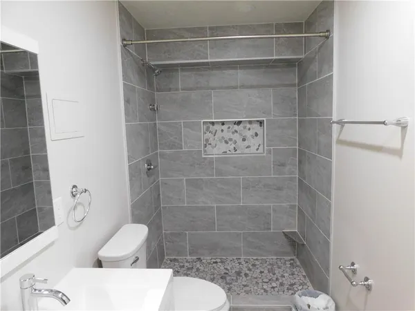 a bathroom with a sink a toilet and shower
