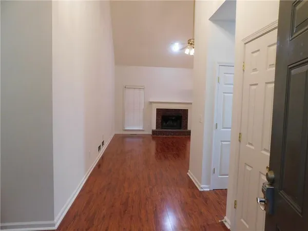 a view of empty room with wooden floor and fireplace