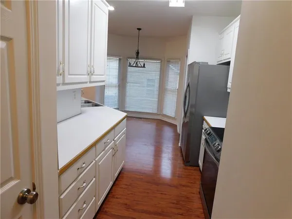 a kitchen with a refrigerator and a wooden floor