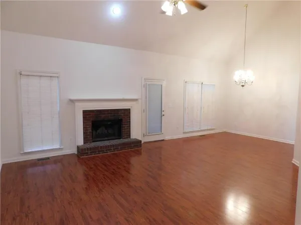 a view of empty room with wooden floor and fireplace