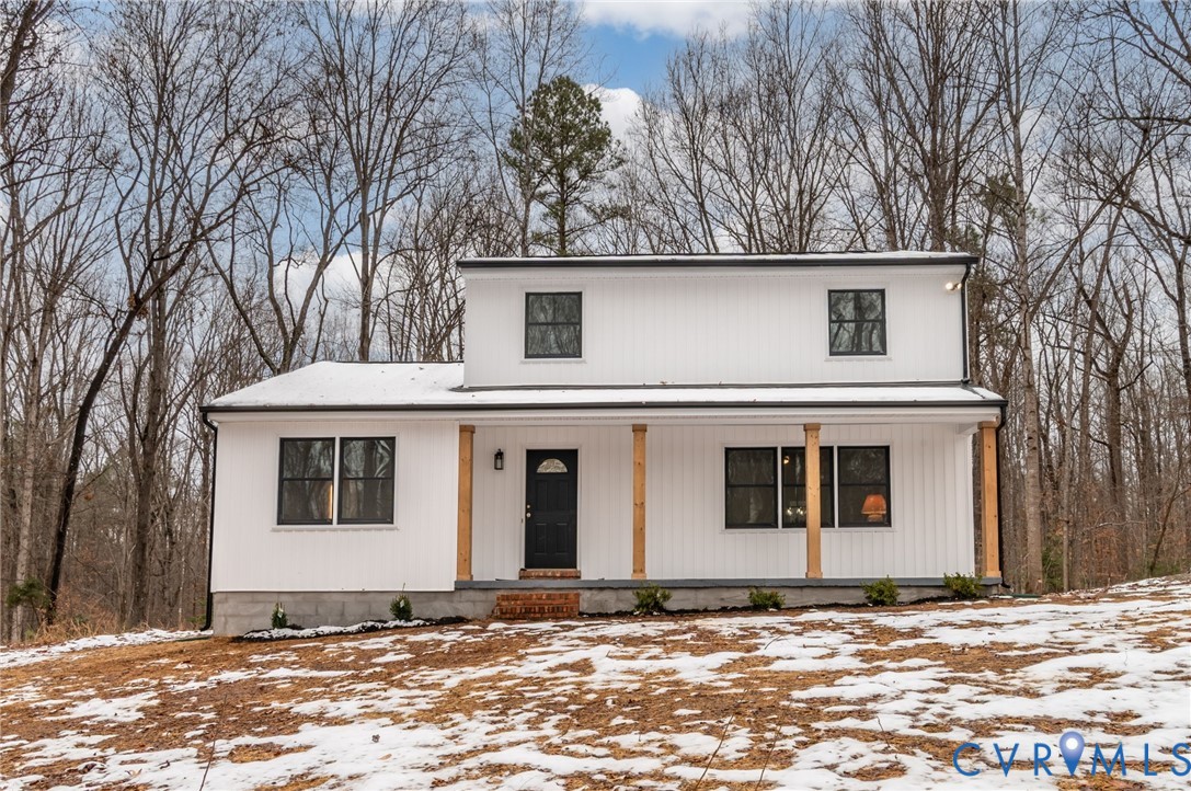a front view of a house with a tree