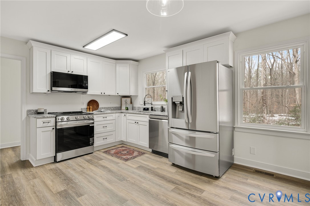16430 St Peters Church Road Montpelier, VA 23192 - Photo 17 of 30 a kitchen with a refrigerator stove and wooden floor