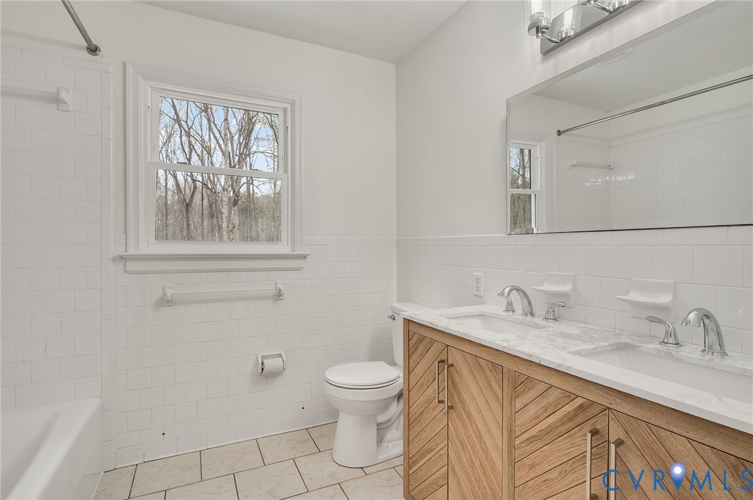 16430 St Peters Church Road Montpelier, VA 23192 - Photo 21 of 30 a bathroom with a granite countertop sink a toilet and a mirror
