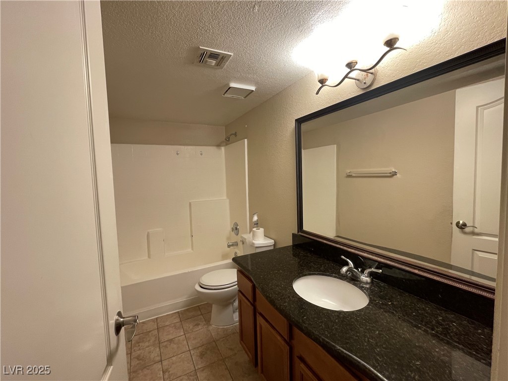 9325 West Desert Inn Road, Unit 149 Las Vegas, NV 89117 - Photo 14 of 20 Bathroom with vanity, a textured ceiling, light tile patterned flooring, and shower / bathtub combination