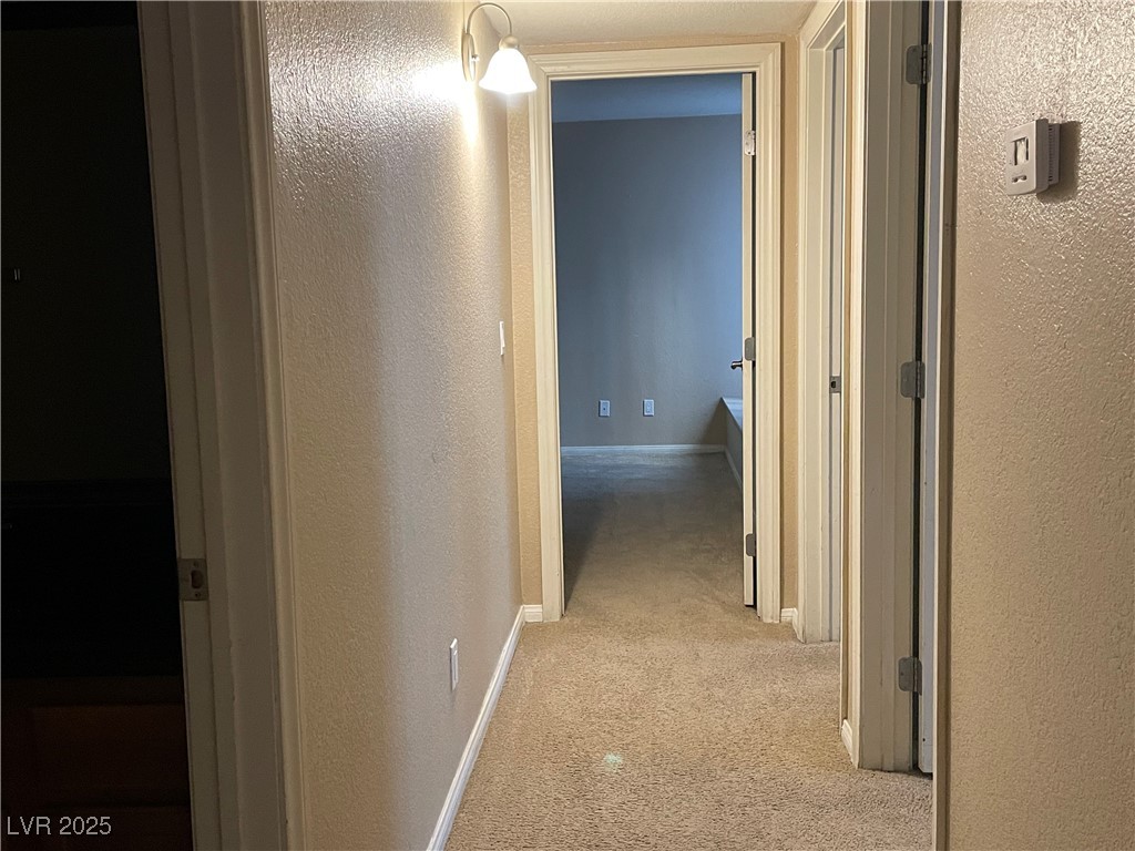 9325 West Desert Inn Road, Unit 149 Las Vegas, NV 89117 - Photo 17 of 20 Hall with light carpet and a textured wall