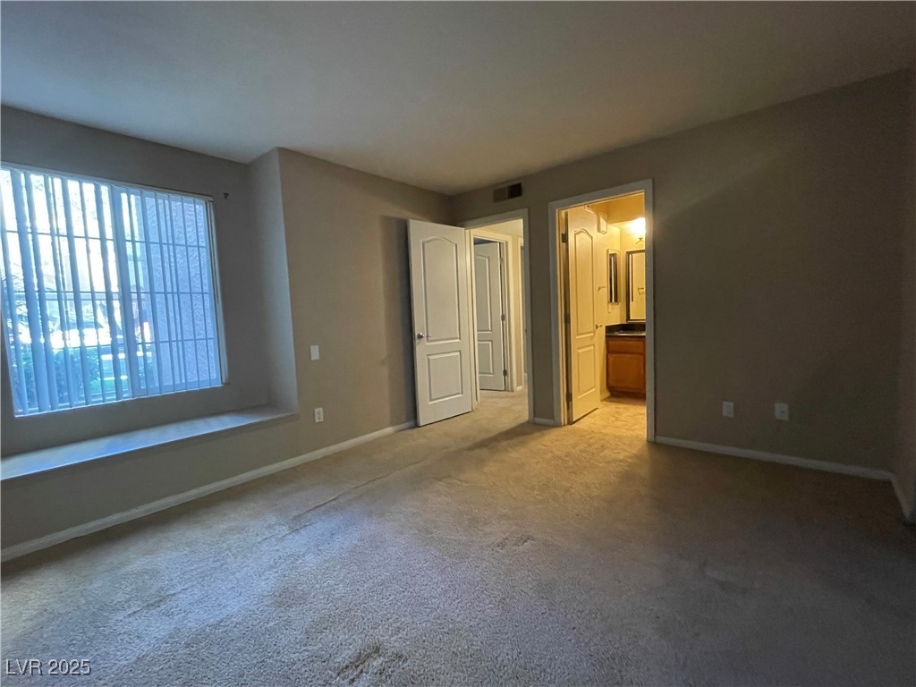 9325 West Desert Inn Road, Unit 149 Las Vegas, NV 89117 - Photo 5 of 20 Unfurnished bedroom with carpet flooring and connected bathroom