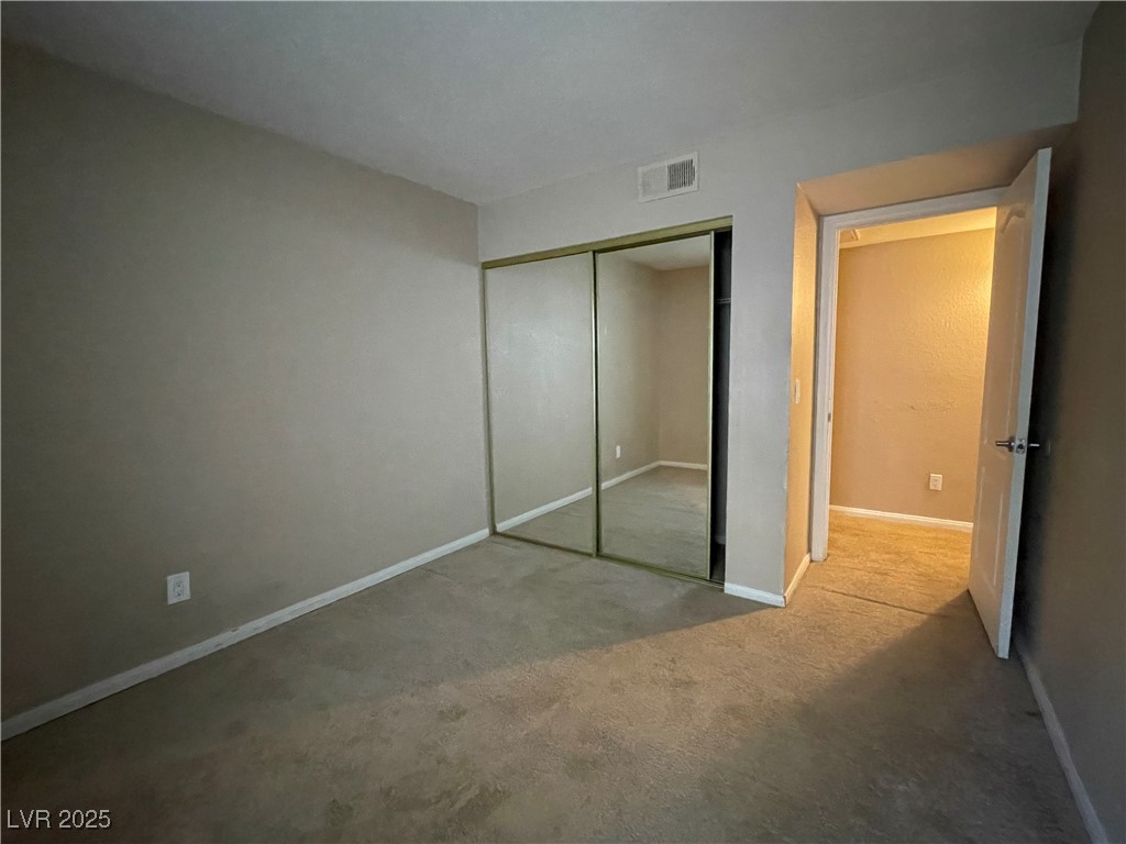 9325 West Desert Inn Road, Unit 149 Las Vegas, NV 89117 - Photo 9 of 20 Unfurnished bedroom with carpet floors and a closet