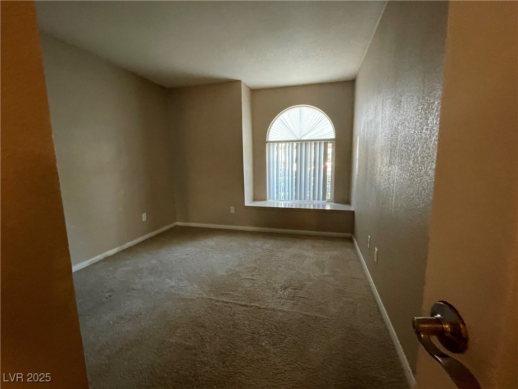 9325 West Desert Inn Road, Unit 149 Las Vegas, NV 89117 - Photo 10 of 20 Empty room with a textured wall and carpet flooring